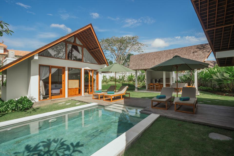 Pool deck with loungers and a shaded outdoor kitchen